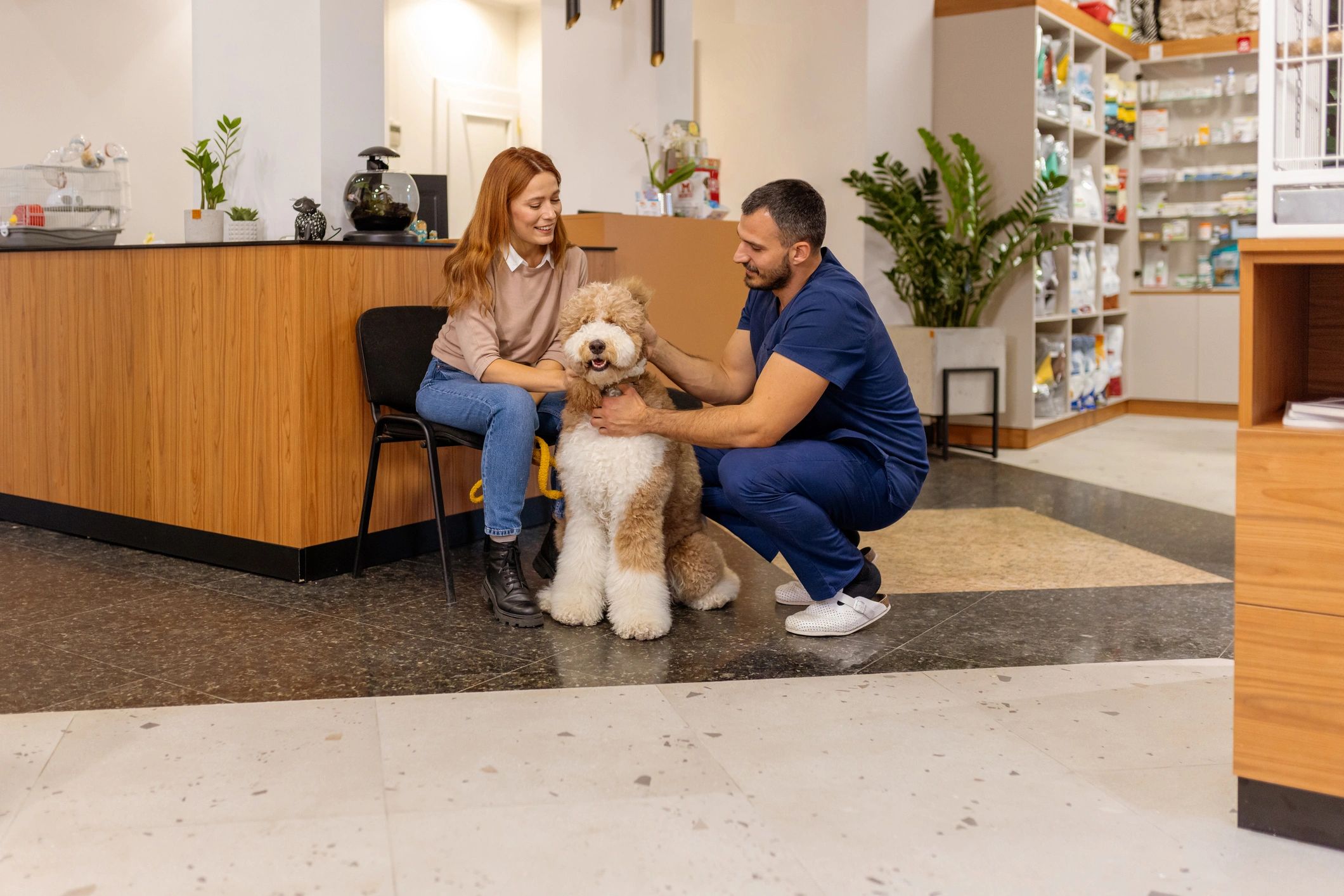 Pet parent with dog and cat at the veterinary clinic
